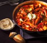 Fish & chorizo stew in a casserole dish with confit garlic aioli