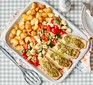 A serving dish with salmon pesto traybake and baby roast potatoes