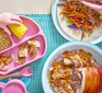 Pieces of orange & oregano pulled pork served on a toddler's plate