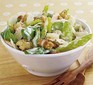 Chicken Caesar salad in a bowl with wooden salad servers