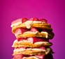 Stack of fluffy pancakes topped with custard and forced rhubarb