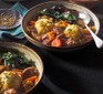 Two bowls of slow cooker beef stew with dumplings