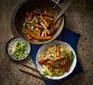 Bowls of noodles with orange glazed pieces of tofu