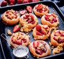 Strawberry buns on tray with icing sugar