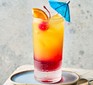 Tequila sunrise in glass with umbrella