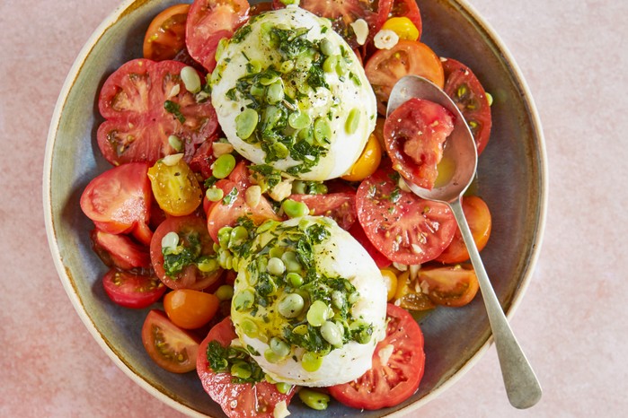 Tomato and burrata salad in a bowl with a spoon